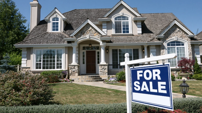 Clean upscale house with a For Sale sign in front